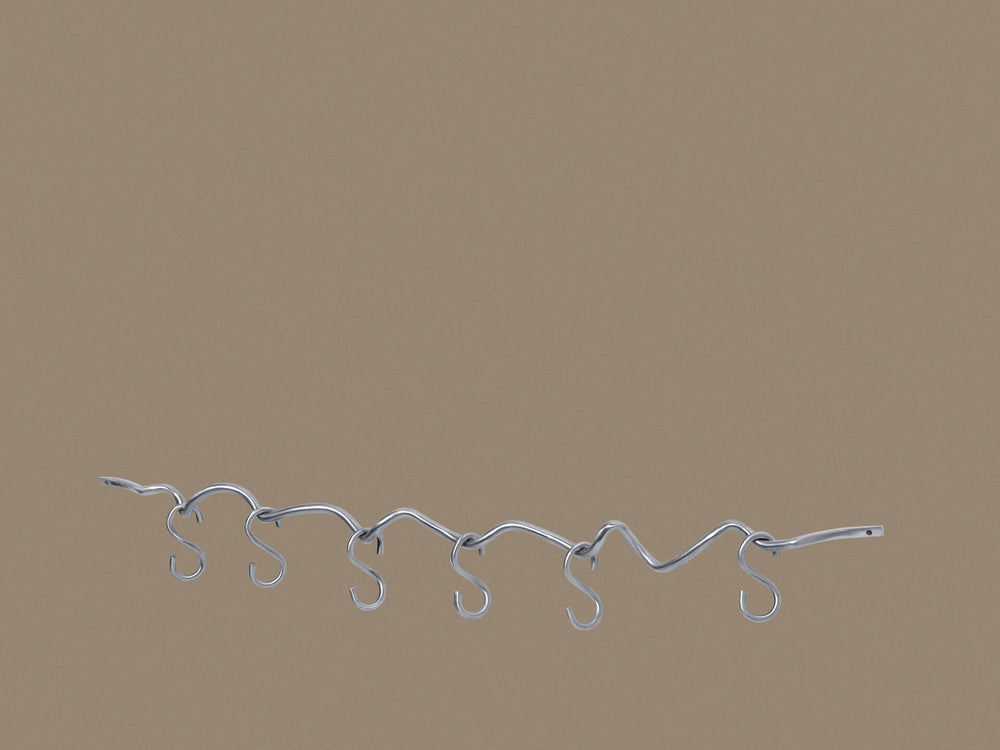 Barra colgante Wavy con seis ganchos en S, montada en una pared beige